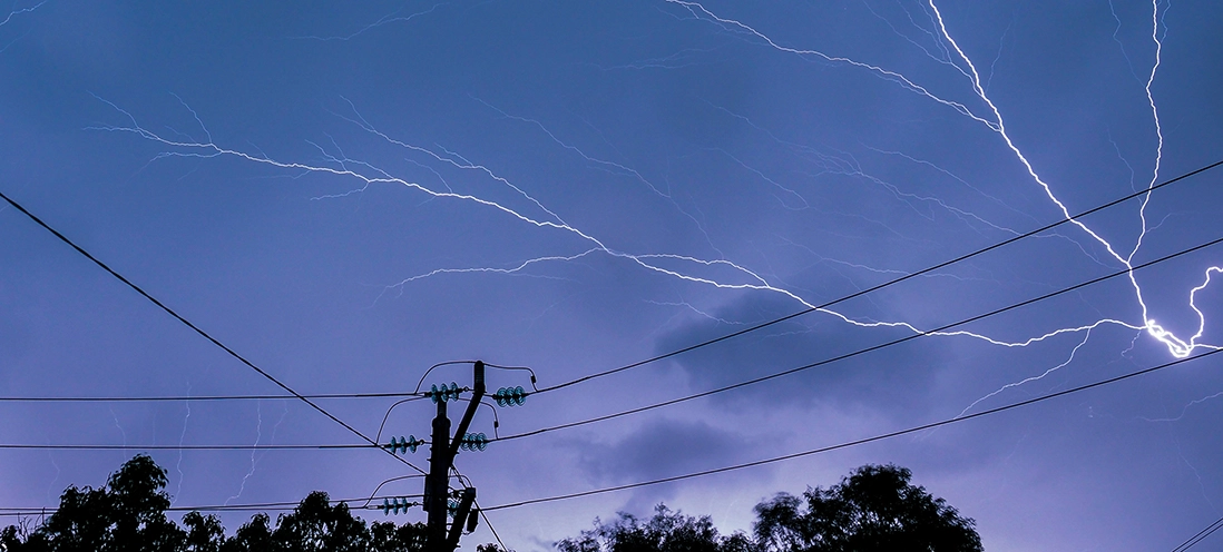 Lightning strikes over power lines.