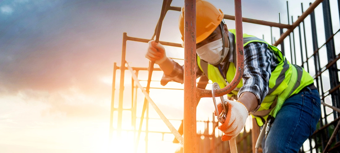 A man in a hardhat working on scaffolding.