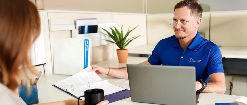 Summit premium auditor sitting at a desk helping client with an audit.